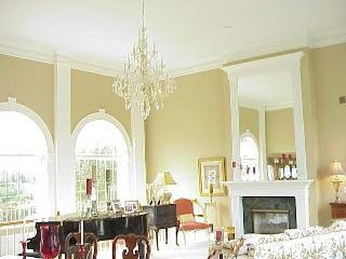 Longwood great room before renovation — dated tan walls and corner fireplace