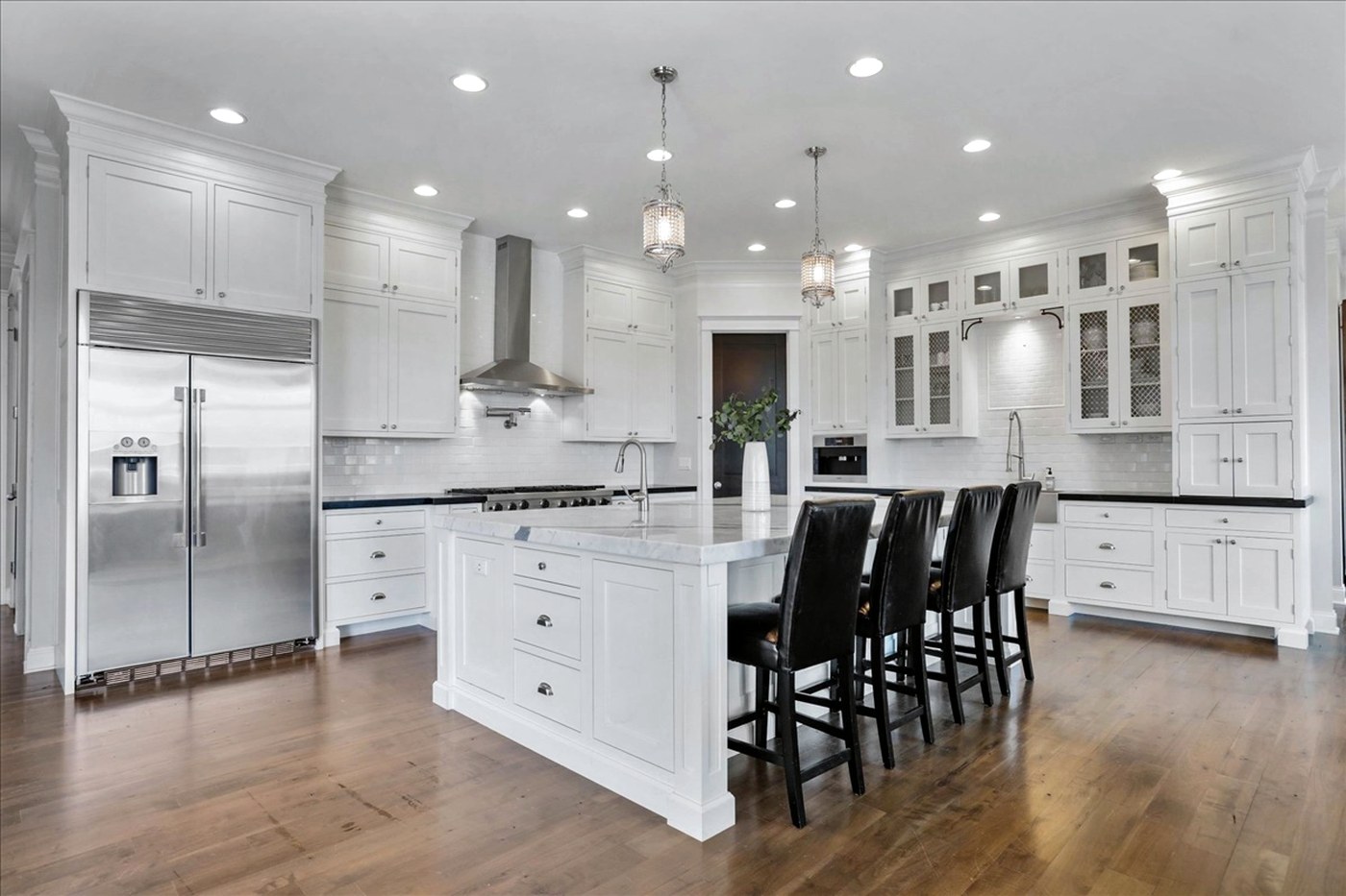 Longwood chef's kitchen with marble island and custom white cabinetry