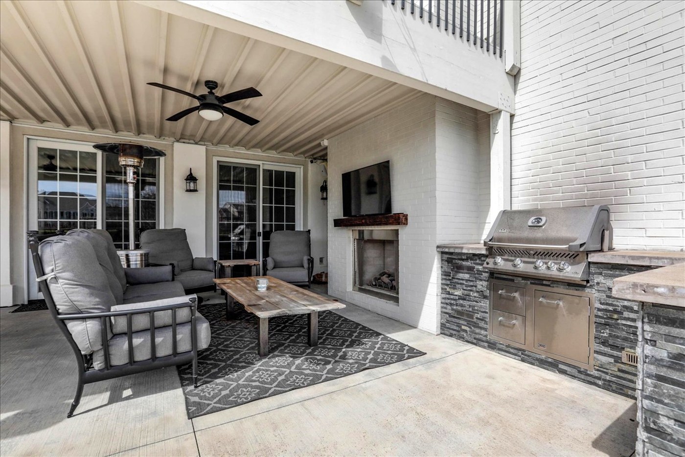 Longwood covered patio with outdoor kitchen and fireplace