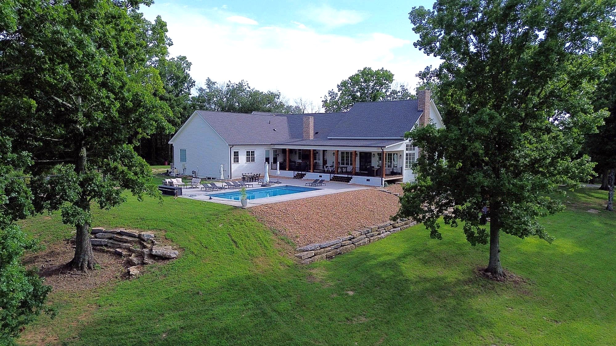 Aerial of custom home and pool framed by oaks — Columbia, TN